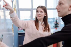 Erklärung an einem Whiteboard vor einer kleinen Gruppe