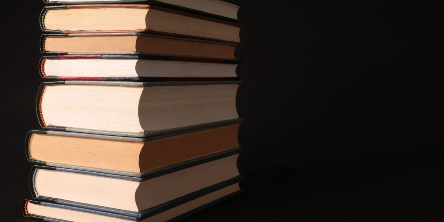 Bücherstapel und Manuskriptseiten auf einem Tisch