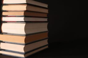 Bücherstapel und Manuskriptseiten auf einem Tisch