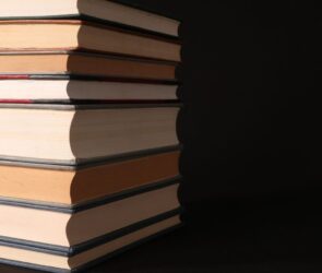 Bücherstapel und Manuskriptseiten auf einem Tisch