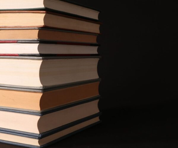 Bücherstapel und Manuskriptseiten auf einem Tisch